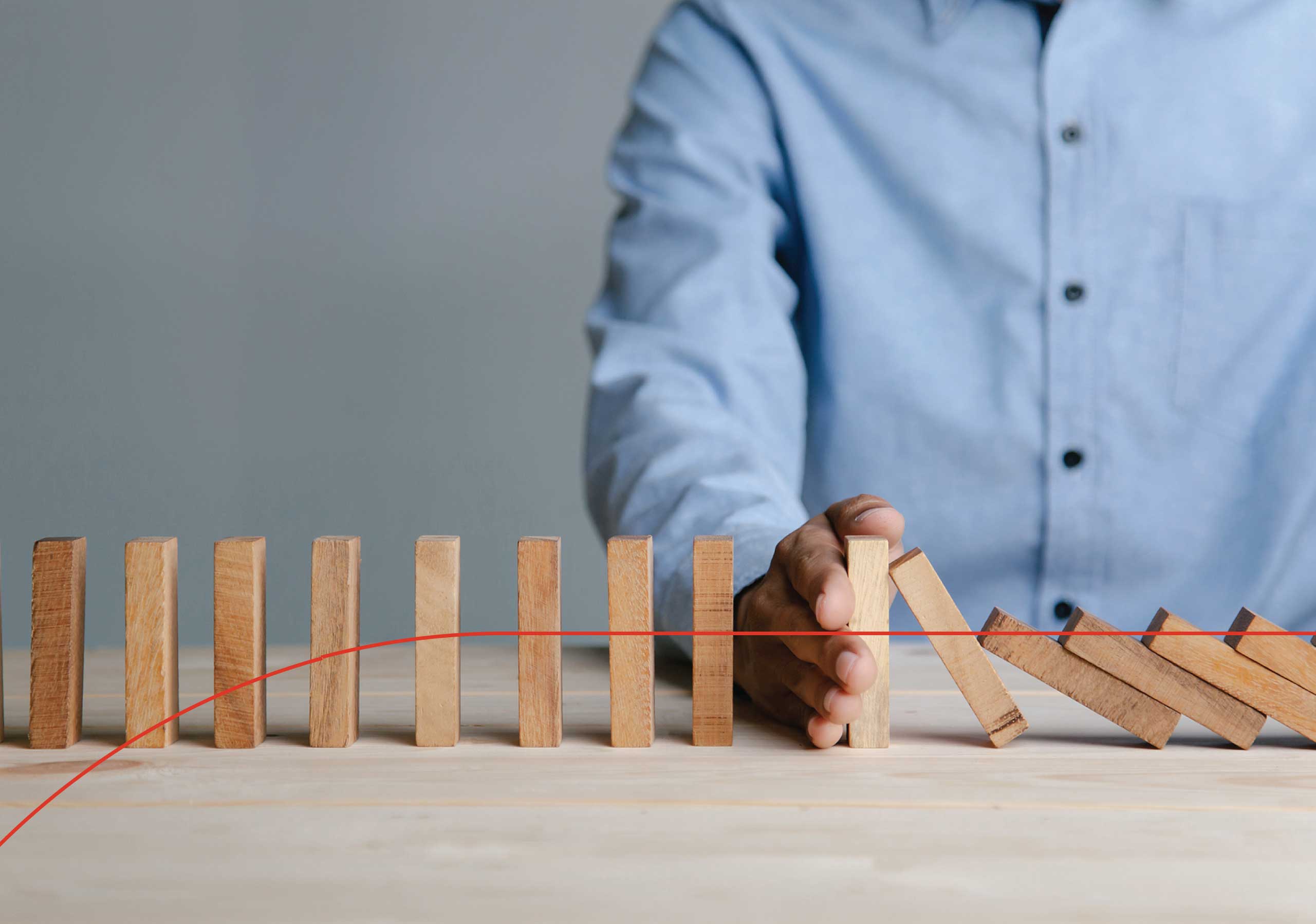 Man stopping dominos from falling.