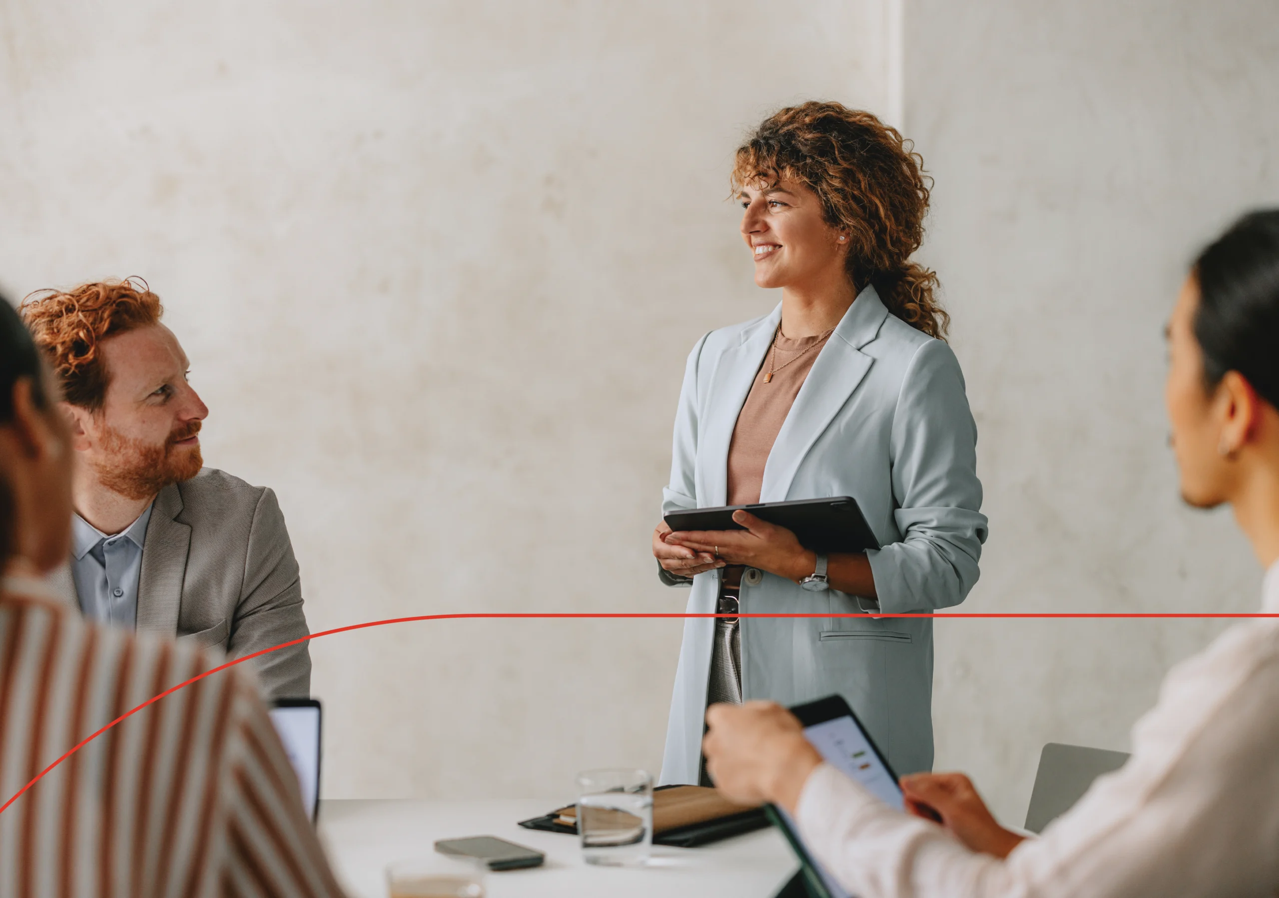Woman stands and discusses with her team how nonprofits can mitigate employee-related risks with Employment Practices Liability Insurance.