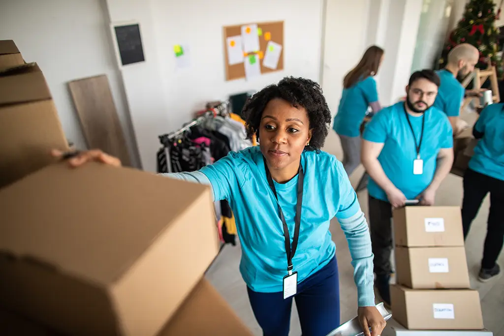 Woman reaches for supplies as a nonprofit event.